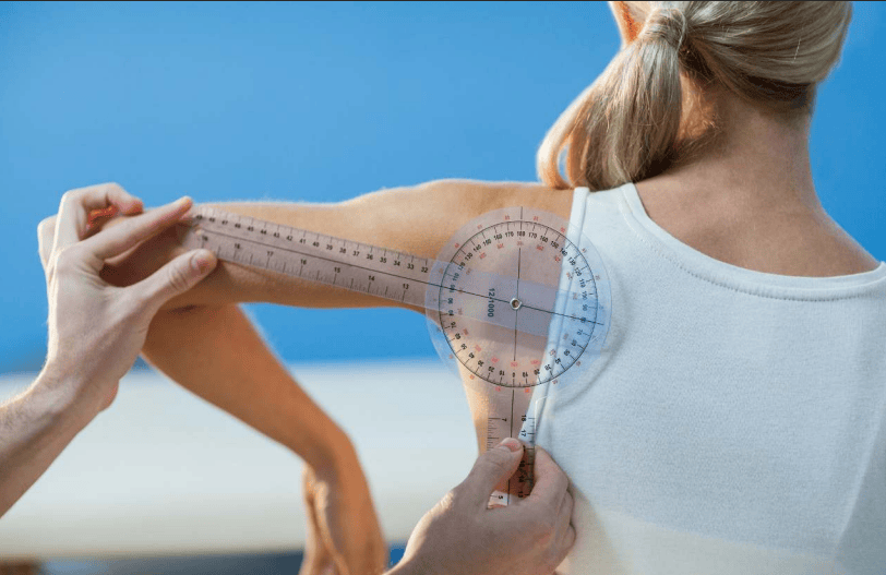 physical therapist measuring shoulder mobility